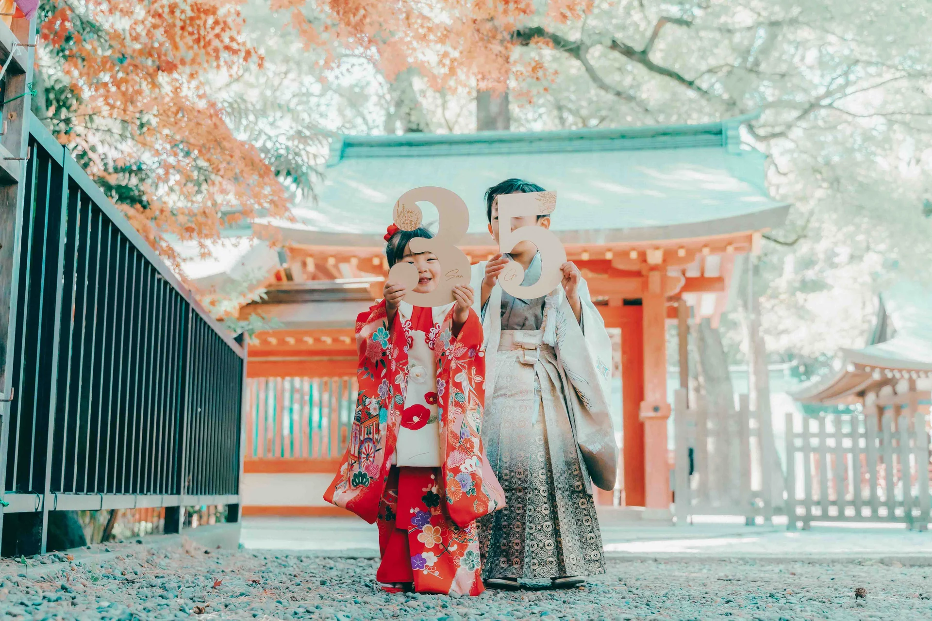 神社の鳥居前で七五三の晴れ着を着た兄妹が記念撮影を楽しむ様子(ハレノヒビフォト神社撮影)